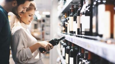 Un couple choisit du vin au supermarché